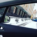 View from the car window of the city. Fresh snow on the sidewalk and roadway. Urban space