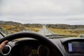 View from car window on the road and pity strange landscape with a mountains, rocks and cloudy sky and hand of woman. Landscape Royalty Free Stock Photo