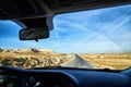 View from car window on the road and strange landscape with a valley, mountains and blue sky with clouds. Landscape through Royalty Free Stock Photo