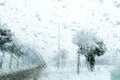 View from the car window on the snow-covered track. Road view through car window during snowfall. Royalty Free Stock Photo