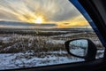 View from the car window at winter sunset in the field, winter sunset, orange bright sunset in the winter field through the window Royalty Free Stock Photo