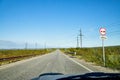 View from car windscreen with stripe relief to highway, tundra and blue sky in norht region at a sunny day Royalty Free Stock Photo