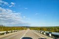 View from car windscreen with stripe relief to highway, tundra and blue sky in norht region at a sunny day Royalty Free Stock Photo