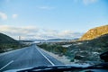View from car windscreen to highway, tundra and hills in evening time. Polar day in Norway Royalty Free Stock Photo