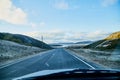 View from car windscreen to highway, tundra and hills in evening time. Polar day in Norway Royalty Free Stock Photo