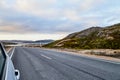 View from car windscreen to highway, tundra and hills in evening time. Polar day in Norway Royalty Free Stock Photo