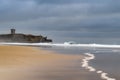 View of the Carcavelos beach in a winter morning with theSao Juliao da Barra Fort with its reflection on the background, and the w