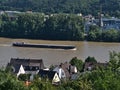 View of cargo barge on Rhine river, an important inland waterway, with high water level passing town Rhens.