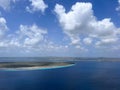View of the Caribbean island of Klein Bonaire from an airplane while landing blue water and blue sky with clouds