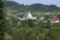 View of the Carpathian village: catholic church, country houses, gardens and mountains. Lugi village, Ukraine Royalty Free Stock Photo