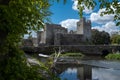A view of the Castle of Cahir across the weir down the River Suir, bright blue sky and fluffy white clouds Royalty Free Stock Photo