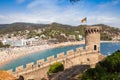 View from the castle hill towards the beach. Castle tower and fragment of walls. Tossa de Mar town in Spain.