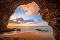 View from the cave a sandy beach along the ocean at sunset Royalty Free Stock Photo