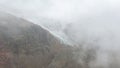 View of the Cayambe volcano glacier going down the slope on a cloudy day