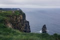 view of the CCliffs of Moher in Ireland with rugged coastline and cloudy sky Royalty Free Stock Photo