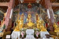 View of the central altar and wall murals in the Ubosot or Ordination Hall of Wat Ming Muang, Nan, Thailand