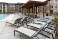 View on the chaise lounge chairs, swimming pool and rooftop dining area in modern residential Royalty Free Stock Photo