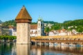 View of Chapel bridge or Kapellbrucke with tower and Jesuit church with clear blue sky Lucerne old town Switzerland