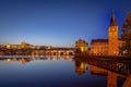 View on Charles Bridge and Prague Castle over Vltava River during early night with wonderful blue sky and yellow city Royalty Free Stock Photo