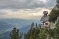 View on a charming small mountain chapel built on the edge of a mountain cliff overlooking the valley in the austrian Alps Royalty Free Stock Photo