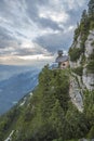 View on a charming small mountain chapel built on the edge of a mountain cliff overlooking the valley in the austrian Alps Royalty Free Stock Photo