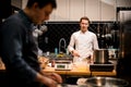 view on chef who neatly mixing ingredients by whisk in steel bowl at restaurant kitchen