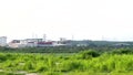 View of a chemical factory with smoking chimneys in the middle of a green rice field in the early morning ~ Factory pipes pollutin