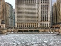 View Chicago riverwalk across a frozen Chicago River and snowflakes during heavy morning snowfall.