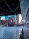 View of Chicago Riverwalk with steam blowing over it and the Chicago River as temps plunge