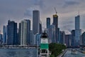 View of Chicago skyline in background, lighthouse in foreground, with Lake Michigan on left with sailboats in harbor