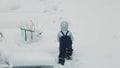 View of child ascend a hill, imprinting tracks in the snow, a representation of winter outdoor activities.