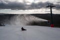 Children on a bobsleigh ride downhill past a snow maker Royalty Free Stock Photo