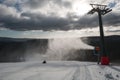 Children on a bobsleigh ride downhill past a snow maker Royalty Free Stock Photo