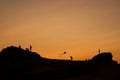 Children silhouettes with kite flying on sunset landscape with rocks