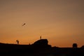 Children silhouettes with kite flying on sunset landscape with rocks