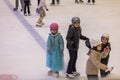 View of children skating on ice rink in sports complex.