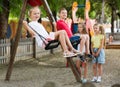 View on children swinging together on children`s playground Royalty Free Stock Photo