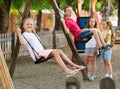 View on children swinging together on children`s playground Royalty Free Stock Photo