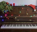 Old piano with keys. Selective focus. Christmas tree with Christmas lights and toys Royalty Free Stock Photo