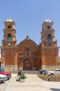 View of the church of Nuestra SeÃ±ora de las Mercedes, view of some tourists and parked cars at noon, located in Carhuaz