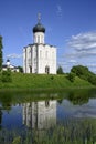 View of the church of Pokrova-na-Nerli and its reflection in the river among trees and meadows in Bogolyubovo, Russia Royalty Free Stock Photo