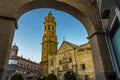 A view of the church of Saint Sebastion in Antequera, Spain framed by an archway