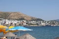 View of the city beach of Bodrum with beach umbrellas on the background of yachts, Marmaris, Turkey, May 2023.