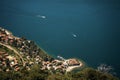 view of the city and the sandy peninsula on the shore of Lake Como from above, two boats cutting through the turquoise water Royalty Free Stock Photo