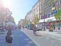 View of city street with biker in hot summer day. People riding bicycles