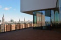 View of the city from the terrace of the high-tech building. The surrounding houses are reflected in the glass windows Royalty Free Stock Photo