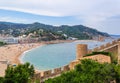 View of the city of Tossa de Mar from the fortress. In the foreground there is a fortress wall and tower