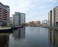 View of clarence dock in leeds looking towards the lock and river with canal boats moored alongside apartment buildings and Royalty Free Stock Photo