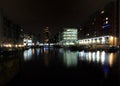 View Of Clarence Dock In Leeds At Night With Waterside Buildings Boats And Lights Reflected In The Water