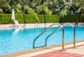 A view of clear blue swimming pool with steel ladder Royalty Free Stock Photo